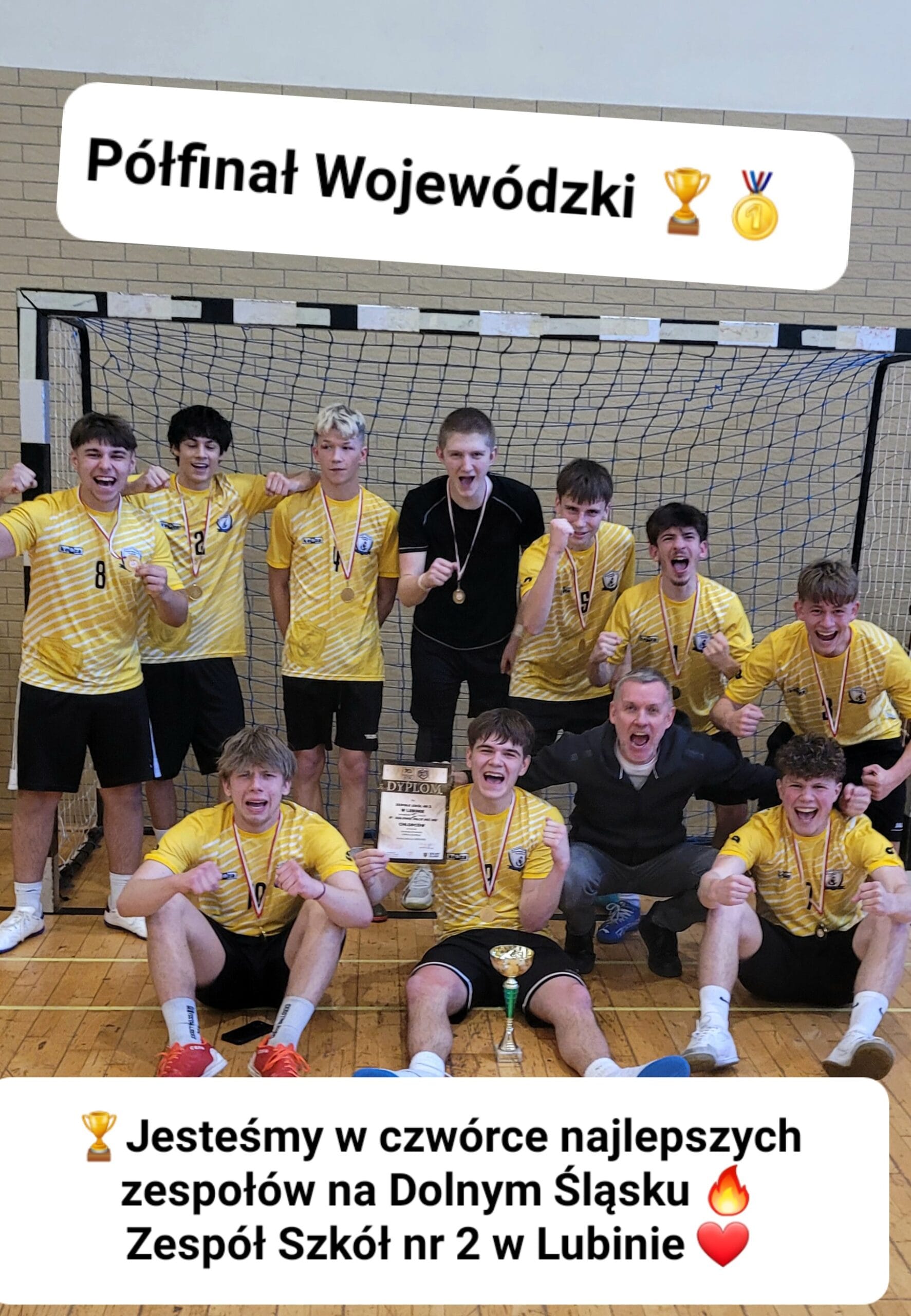 Pamiątkowe zdjęcie drużyny chłopców z Zespołu Szkół nr 2 w Lubinie, świętujących sukces w turnieju sportowym. Grupa nastolatków w żółto-białych koszulkach z medalami na szyjach pozuje z dyplomem i pucharem na tle bramki do piłki ręcznej. Wszyscy są bardzo radosni i krzyczą z entuzjazmu.