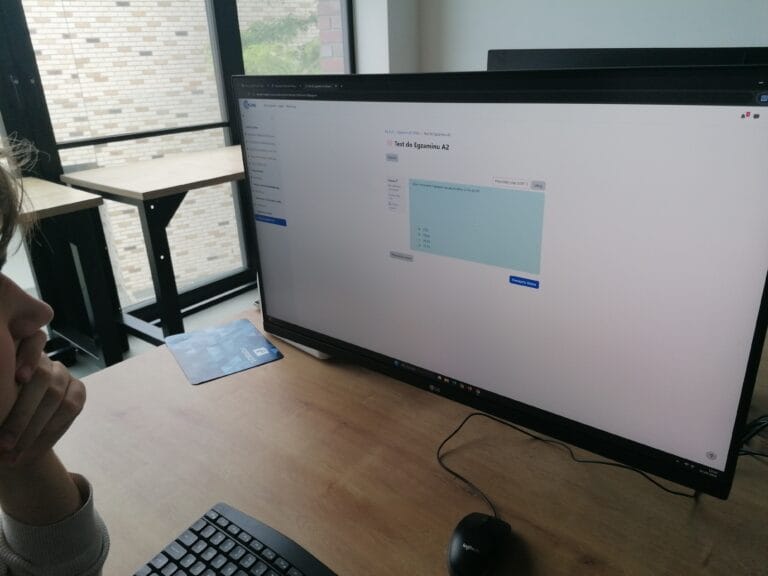Zbliżenie na monitor komputera, na którym wyświetla się pytanie o napięcie znamionowe akumulatora w ramach Testu do Egzaminu A2